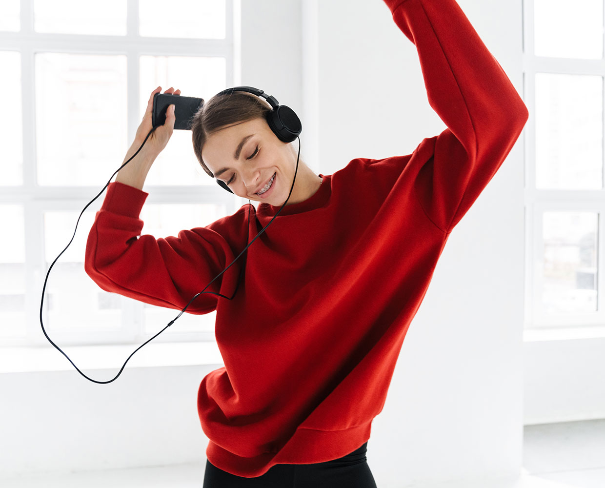 A girl wearing headphones and dancing