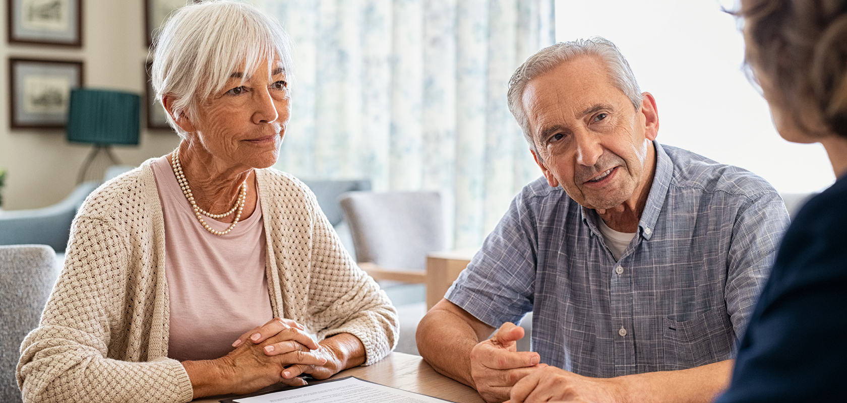 Senior man and woman at table discussing end-of-life care
