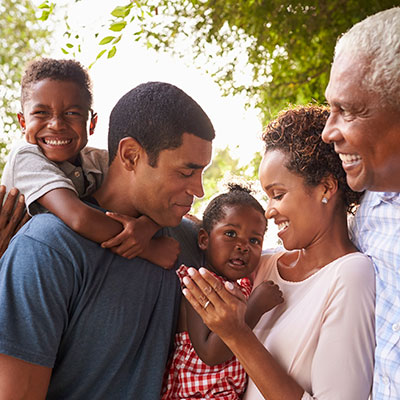 Multigenerational African American family gathered outside on sunny day