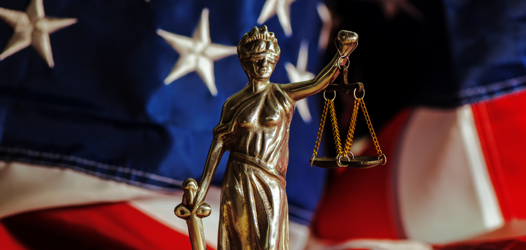 Scales of justice statuette in from of American flag