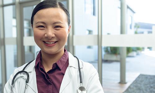 Smiling Asian woman doctor with stethescope