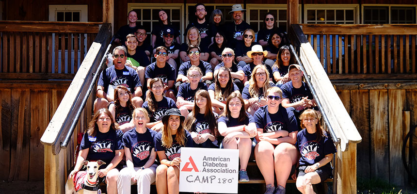 Campers with dog smiling on steps of cabin at New Mexico diabetes camp 180