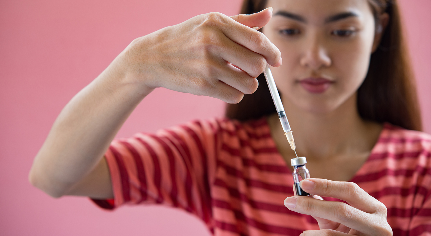 Woman drawing up insulin into syringe