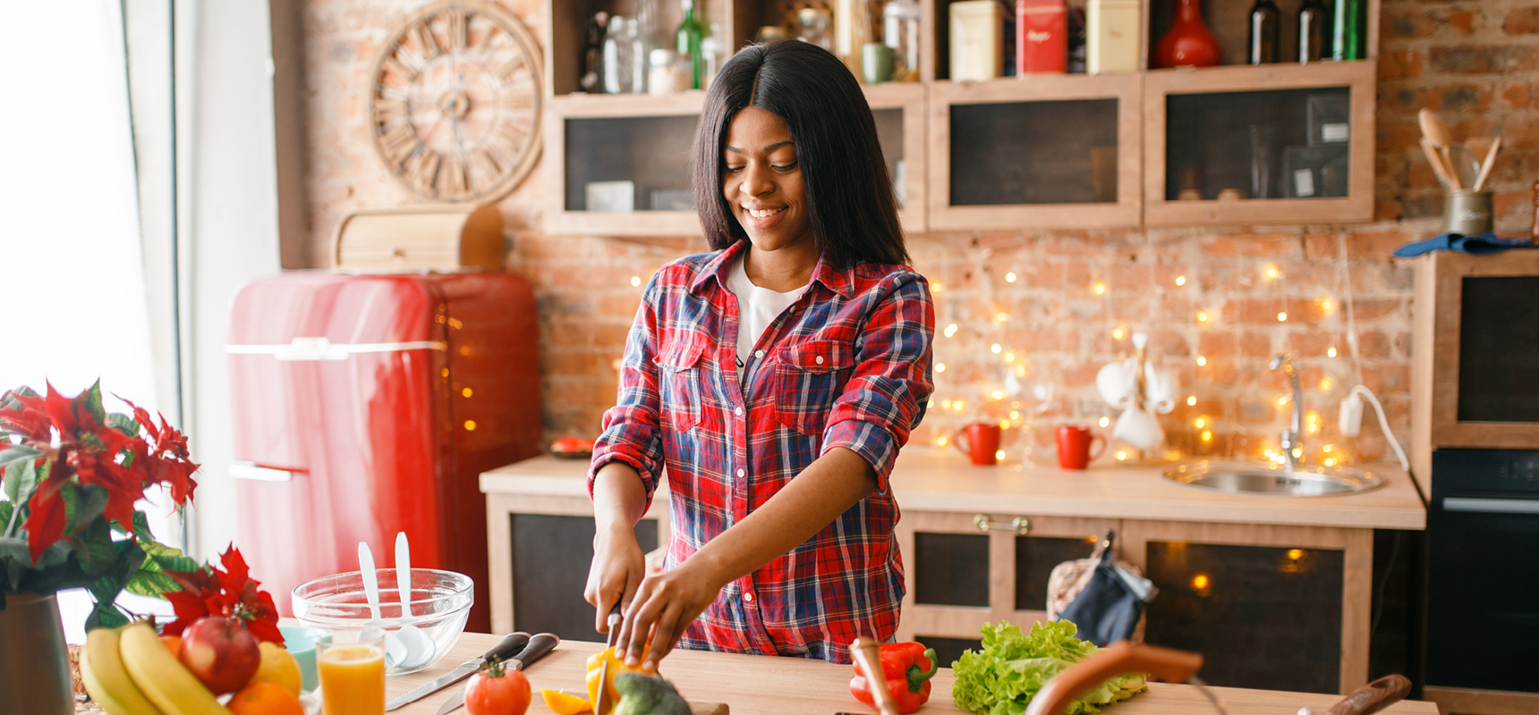 Smiling African American woman cooking healthy food in kitchen