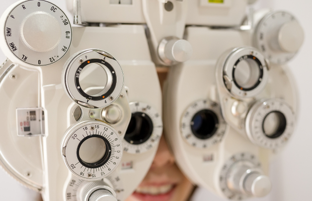 close-up of smiling person getting eyes tested on machinery