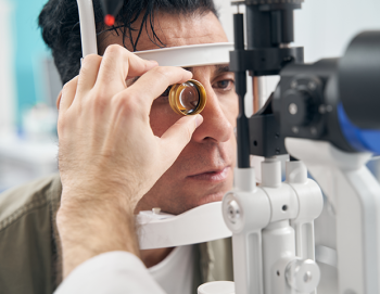 Man getting eye exam with optometrist inspecting eye